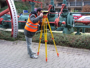 Ein Student nivelliert auf dem Campus Deutz