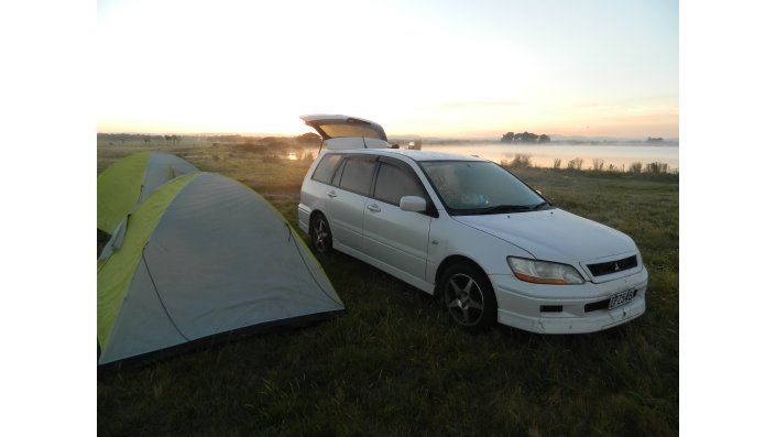 Ein Auto neben einem Campingzelt