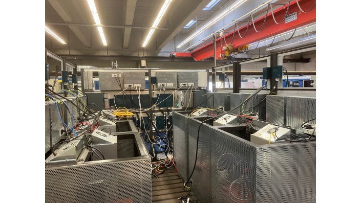 Es sind die Rückseiten der 6 Racks sowie die Rückseite des Topologie-Konfigurators zu erkennen