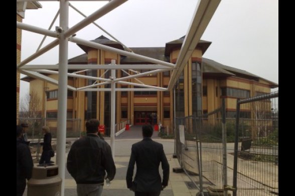 Zwei Menschen von hinten laufen auf den Eingang der Staffordshire University zu