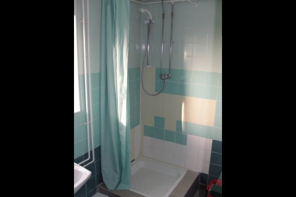Eine Dusche mit türkisfarbenem Duschvorhang