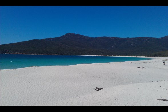 Weißer Sandstrand und tiefblaues Wasser