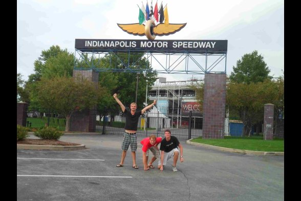 Drei junge Männer vor dem Eingangsschild der Rennstrecke von Indianapolis