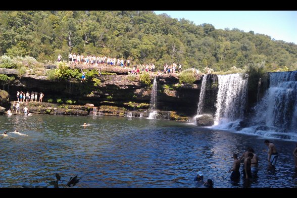 Ein Wasserfall mit vielen Schaulustigen und Badenden