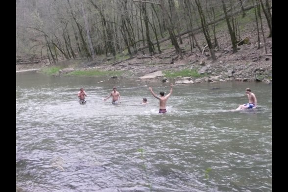 Junge Mensche in Badekleidung in einem Fluss