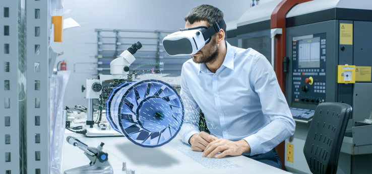 Mann mit Kopfhörer und Turbine auf dem Tisch vor ihm (Bild: gorodenkoff/istock.com)