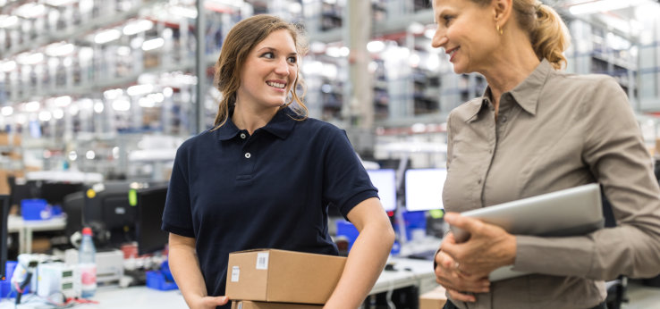 Zwei Personen gehen durch ein Lager. (Image: alvarez/istock.com)