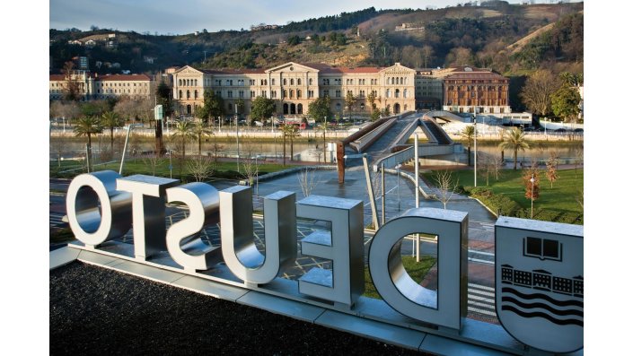 Antikes Gebäude und Schriftzug "Deusto" im Vordergrund