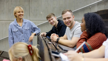 Fünf Studierende treffen sich in einem Vorlesungssaal (Bild: Hanna Witte/TH Köln)