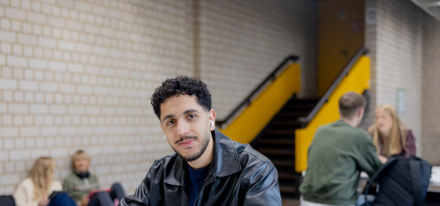 Ein männlich gelesener Studierender arbeitet mit einem iPad im Gebäude am Campus Deutz. Im Hintergrund arbeiten weitere Studierende (Bild:Hanna Witte/TH Köln)