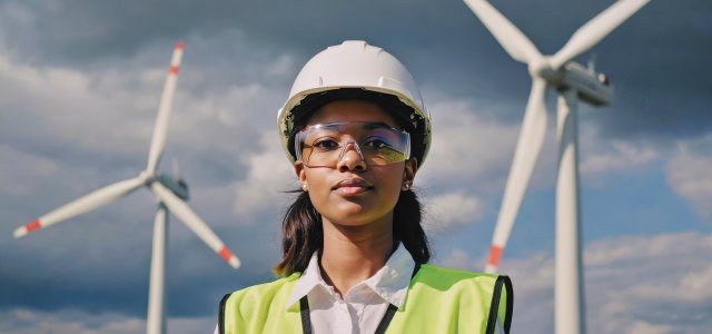 junge Frau vor Windrädern (Bild:Adobe Stock)