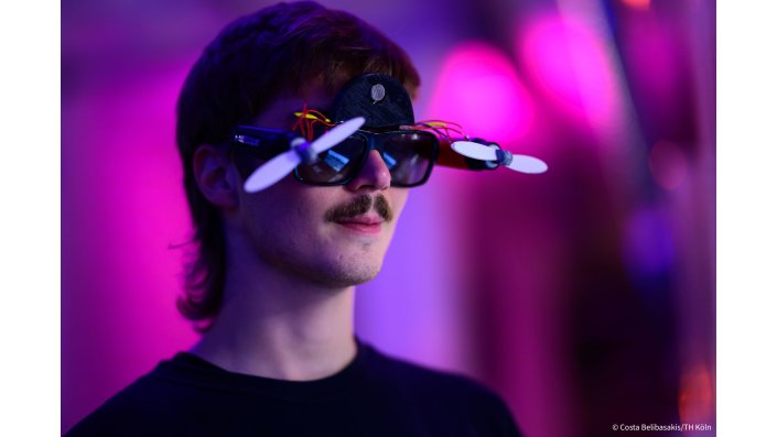 Person vor lila Hintergrund trägt Prototyp einer Sonnenbrille mit Propellern
