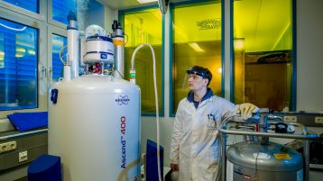 Ein Doktorand arbeitet an dem Nuclear Magnetic Resonance Spectroscopy (NMR) Gerät Ein Doktorand arbeitet an dem Nuclear Magnetic Resonance Spectroscopy (NMR) Gerät