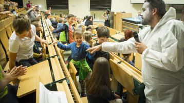 Eisbär Andreas zeigt den Kindern im Hörsaal seine trockene Hand (Bild: Heike Fischer/TH Köln)