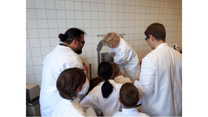 Dr. Andreas Schüren und Thomas Millenautzki stellen mit SchülerInnen der KinderUni Apfelsaft her