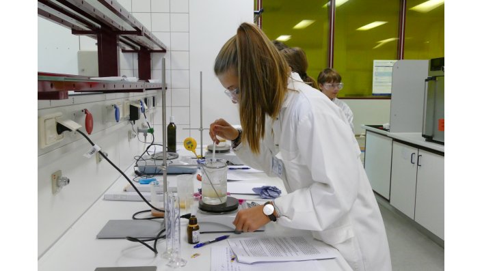Schülerin mischt Substanzen für Seifen im Labor zusammen