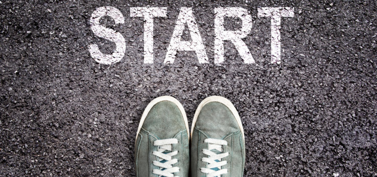 Sneaker shoes and the word START written on asphalt ground (Bild: Start_AdobeStock_Delphotostock_255575819)