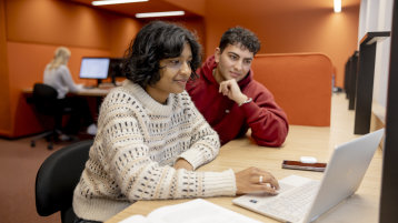 Zwei Studierende schauen gemeinsam auf einen Laptop. (Bild: Hanna Witte,TH Köln)