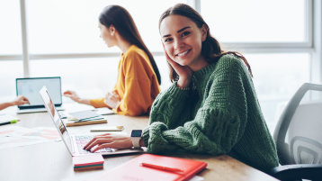 Zwei Personen sitzen am Tisch und arbeiten am Laptop (Bild: AdobeStock/ 302727735)