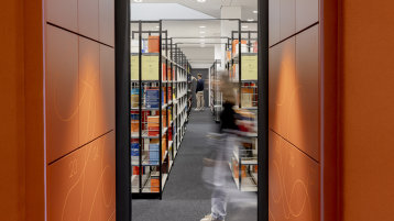 Studierende zwischen den Regalen in der Bibliothek. (Bild: Hanna Witte,TH Köln)
