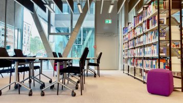 Lernplätze vor großer Fensterfront und Bücherregalen  (Bild: TH Köln/ Alina Beier)