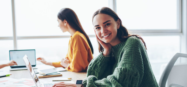 Zwei Personen sitzen am Tisch und arbeiten am Laptop (Bild:AdobeStock/ 302727735)
