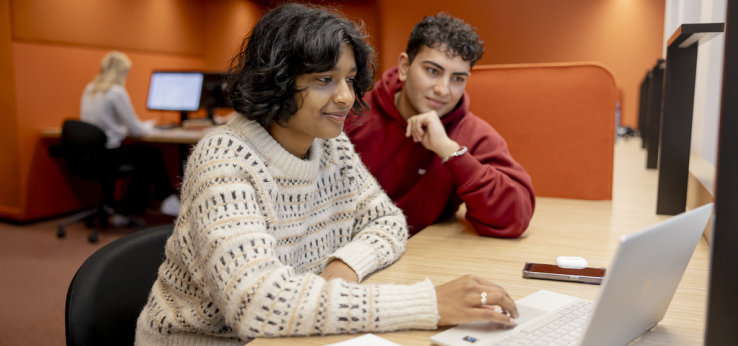 Zwei Studierende schauen gemeinsam auf einen Laptop. (Bild: Hanna Witte,TH Köln)