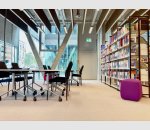 Lernplätze vor großer Fensterfront und Bücherregalen