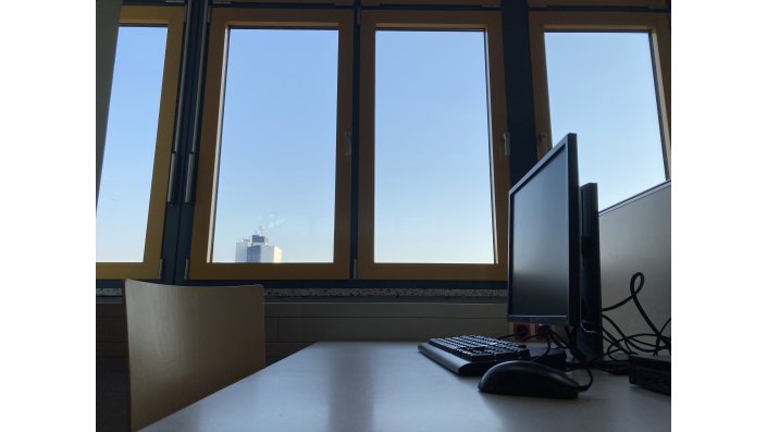 Stuhl und Tisch mit PC mit Fenster im Hintergrund