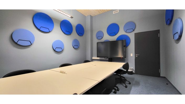 Blick in Lernraum zeigt mobile Tische und Stühle, Smartboard an der Wand