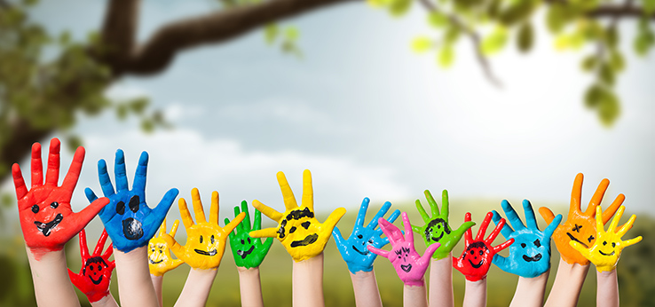 Bunt bemalte Kinderhände strecken sich in die Luft (Bild: Fotogestoeber / Adobe Stock)