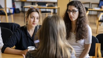 Zwei Studentinnen tauschen sich beim Working@TH Köln-Gettogether aus.