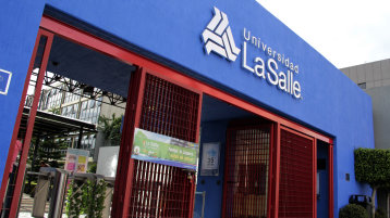 Eingang der Universidad La Salle in Mexiko mit blauem Gebäude, weißem Logo und Schriftzug sowie roten Eingangstoren. (Bild: Guillermina Galindo, Universidad La Salle Mexico)