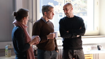 Drei Mitglieder führen bei einer Tasse Kaffee ein Austauschgespräch. (Bild: ZLE TH Köln)