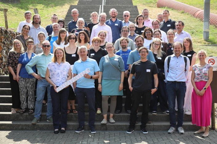 Gruppenfoto des Symposiums und Staffelstabübergabe vor der Treppe von :metabolon