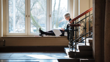 Foto: Frau notiert im Programmheft am Fenster an der Cafebar Claudiusstraße (Image: Costa Belibasakis)