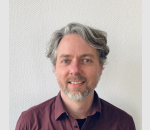 Matthias Wiemer trägt ein rotes Hemd, steht vor einer weißen Wand und hat kurze Haare.