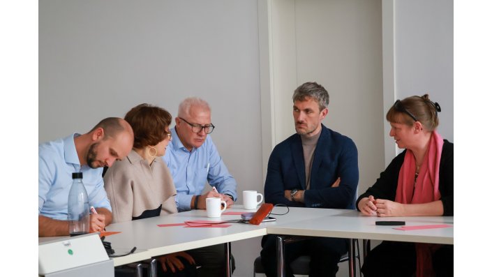 Mitglieder des EZ diskutieren an einem Tisch.