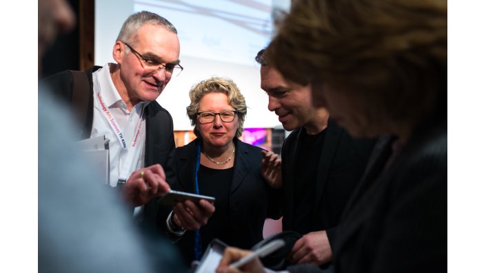 Foto: Ministeriin Schulze mit mehreren Teilnehmenden in Diskussion