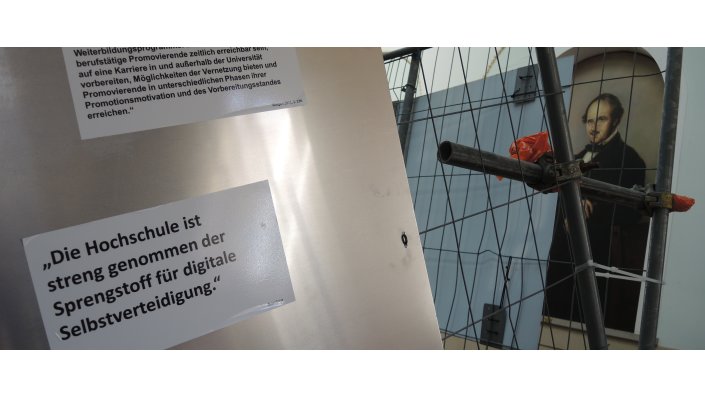 Foto: Zitat am Bauzaun: Die Hochschule ist streng genommen der Sprengstoff fr digitale Selbstverteidigung