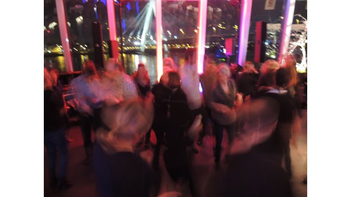 Foto: Unscharf: Mehrere Personen tanzen vor Rheinkulisse bei der Conference Party