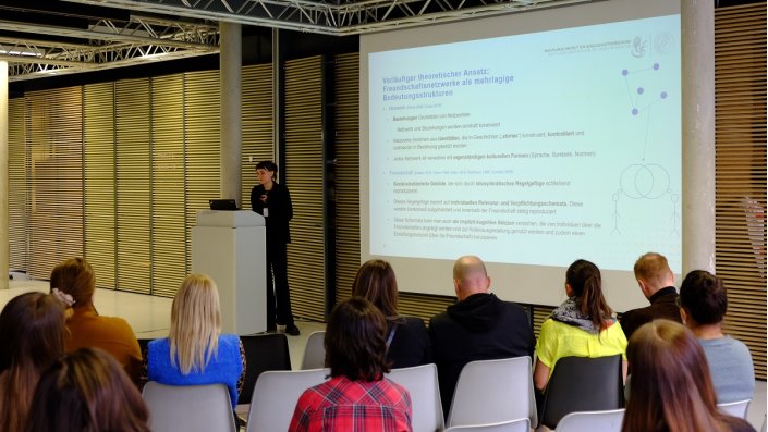 Frau neben Projektion einer Präsentation