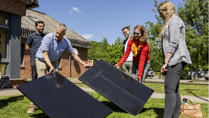 fünf Menschen mit Solarpanelen