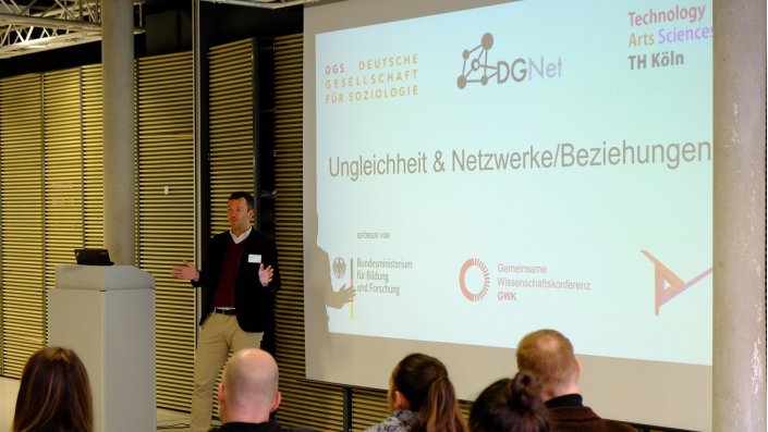 Mann neben Projektion einer Präsentation