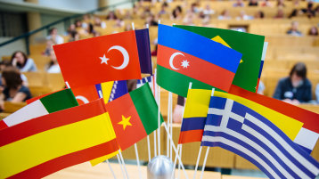 Flaggen verschiedener Länder im Hörsaal (Bild: Costa Belibasakis / FH Köln)