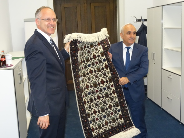Ein Delegationsmitglied überreicht dem Präsidenten der FH Köln einen Teppich als Gastgeschenk Ein Delegationsmitglied überreicht dem Präsidenten der FH Köln einen Teppich als Gastgeschenk