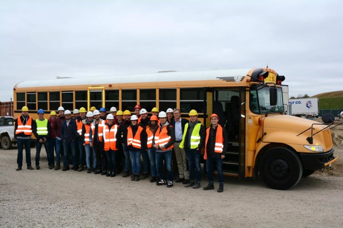 Die Exkursionsgruppe steht vor einem typisch amerikanischen Schulbus.