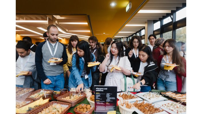 Internationale Studierende befüllen ihre Teller mit den Leckereien des internationalen Buffets. 