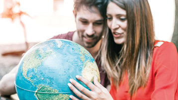 Zwei Studierende schauen auf einen Globus (Bild: PJPhoto69)