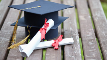Zwei Absolvent*innen-Hüte sowie zwei Urkunden (Bild: Ancika/iStockphoto.com) Zwei Absolvent*innen-Hüte sowie zwei Urkunden (Bild: Ancika/iStockphoto.com)